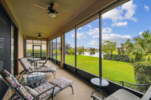 sunroom with a water view and ceiling fan