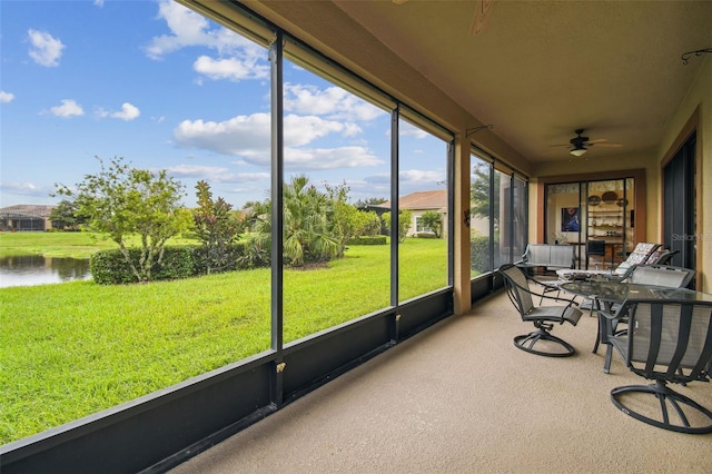 sunroom / solarium with a water view and ceiling fan