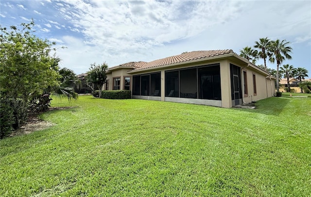 back of property with a sunroom and a yard