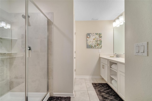 bathroom with a stall shower, tile patterned flooring, vanity, and baseboards