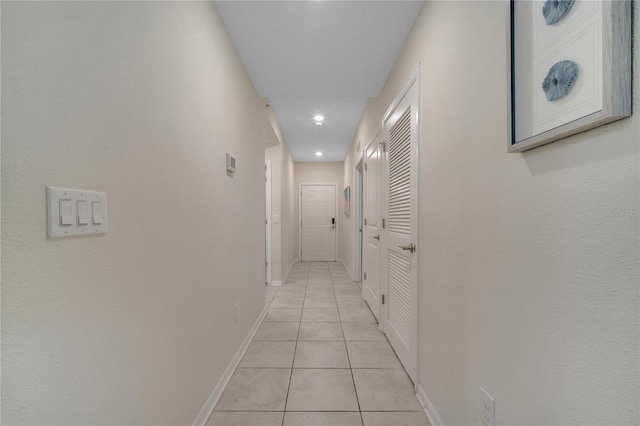 corridor with baseboards and light tile patterned floors