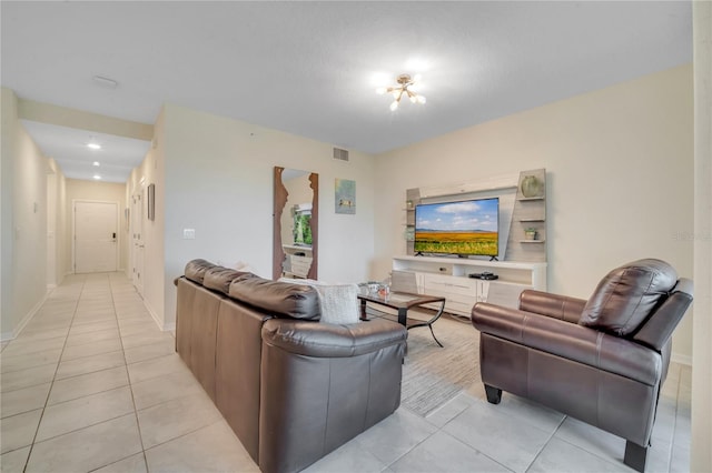 living area featuring light tile patterned flooring, visible vents, and baseboards