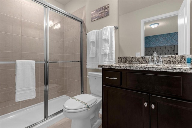 bathroom featuring tile patterned flooring, walk in shower, toilet, and vanity