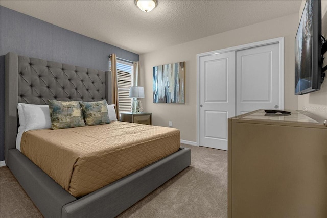 carpeted bedroom featuring a textured ceiling and a closet