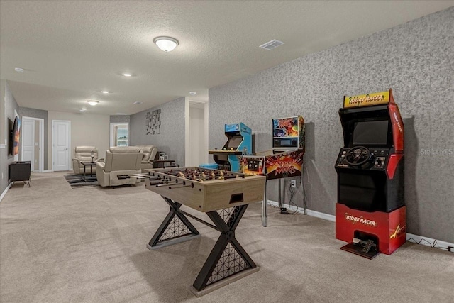 game room with a textured ceiling and carpet flooring