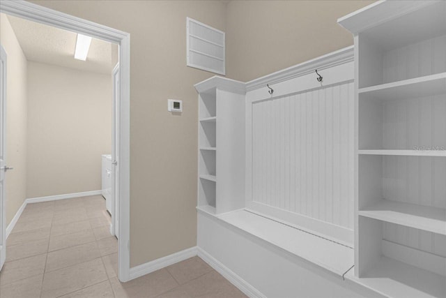 mudroom featuring a textured ceiling and light tile patterned floors