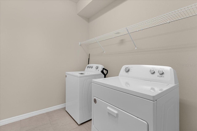 laundry room featuring washing machine and clothes dryer and light tile patterned floors