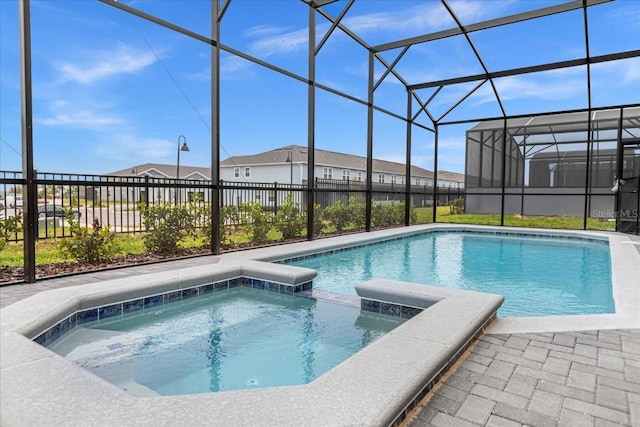 view of pool with a lanai and an in ground hot tub