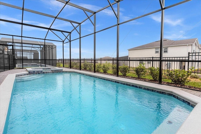 view of pool featuring glass enclosure and an in ground hot tub