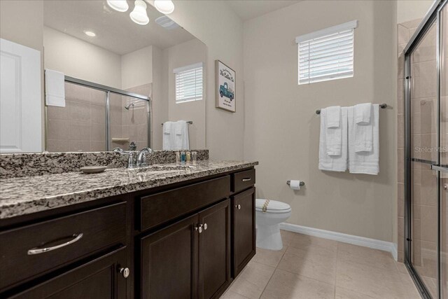 bathroom with a shower with shower door, tile patterned flooring, toilet, and vanity