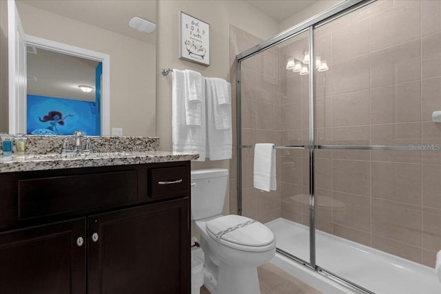 bathroom with a shower with door, vanity, and toilet