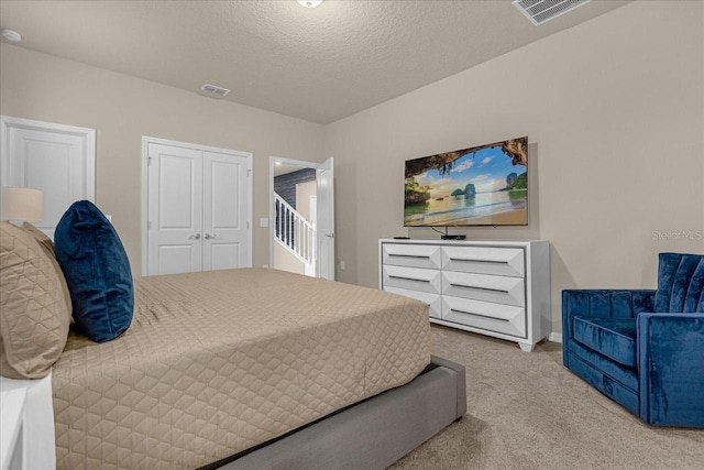 carpeted bedroom featuring a textured ceiling