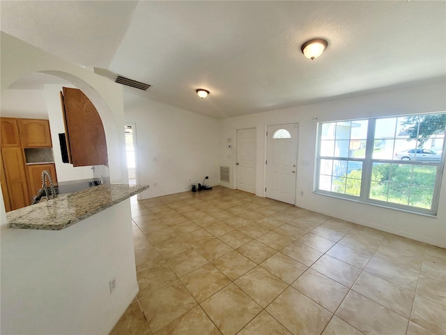 entrance foyer with arched walkways, visible vents, and light tile patterned flooring