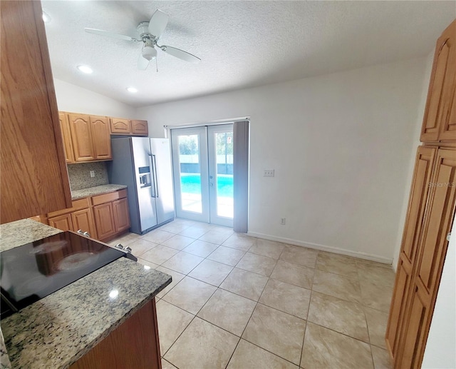 kitchen with ceiling fan, a textured ceiling, french doors, stainless steel refrigerator with ice dispenser, and decorative backsplash