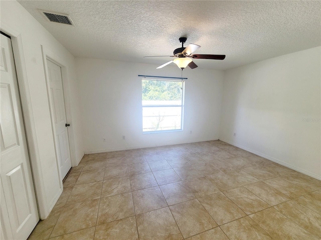 unfurnished bedroom with light tile patterned floors, baseboards, visible vents, ceiling fan, and a textured ceiling