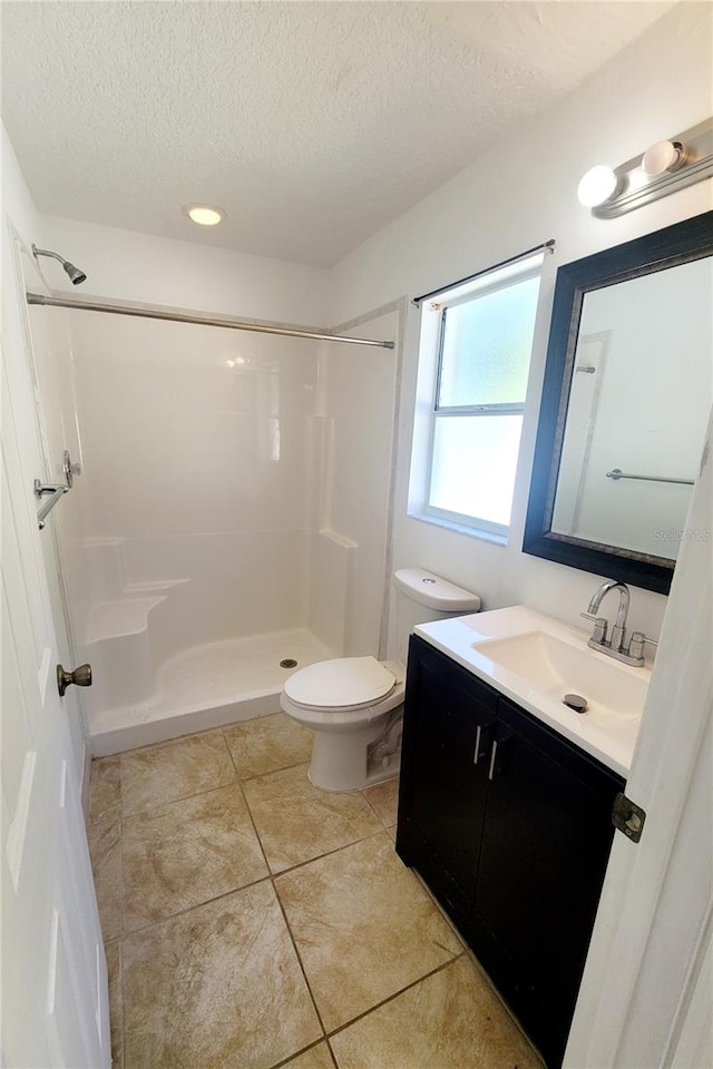 full bathroom featuring toilet, tile patterned floors, a textured ceiling, vanity, and a shower stall