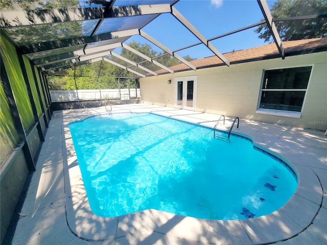 view of swimming pool with a lanai, a fenced in pool, a patio, and french doors