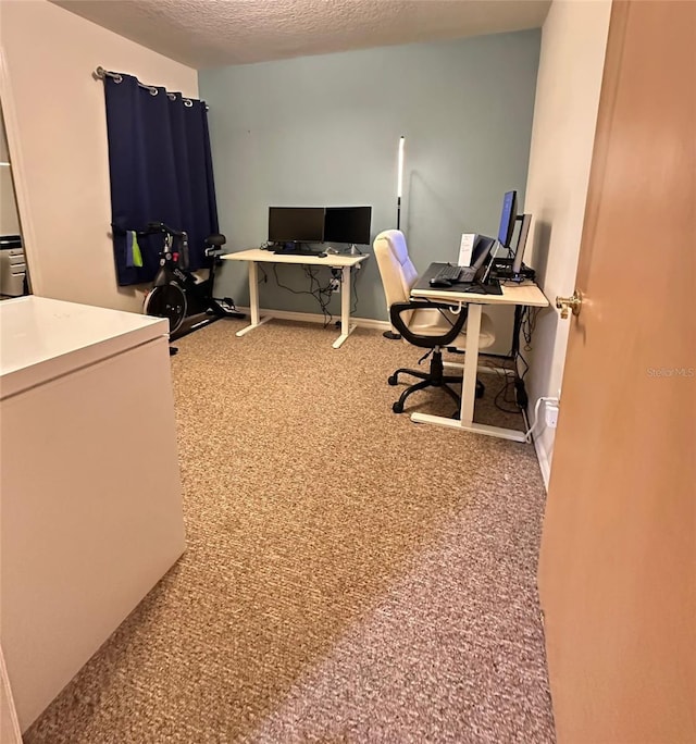 carpeted office space featuring a textured ceiling