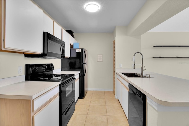 kitchen featuring black appliances, a peninsula, a sink, and light countertops