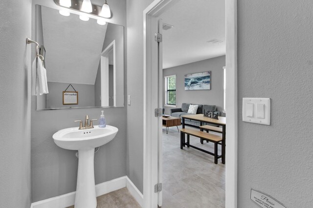 bathroom with tile patterned flooring and vaulted ceiling