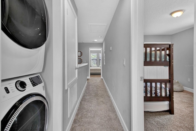 clothes washing area featuring light colored carpet and stacked washer and dryer