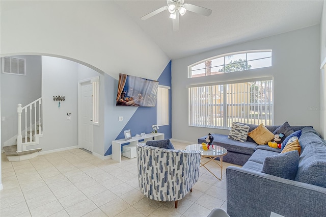 tiled living room featuring a textured ceiling, high vaulted ceiling, and ceiling fan