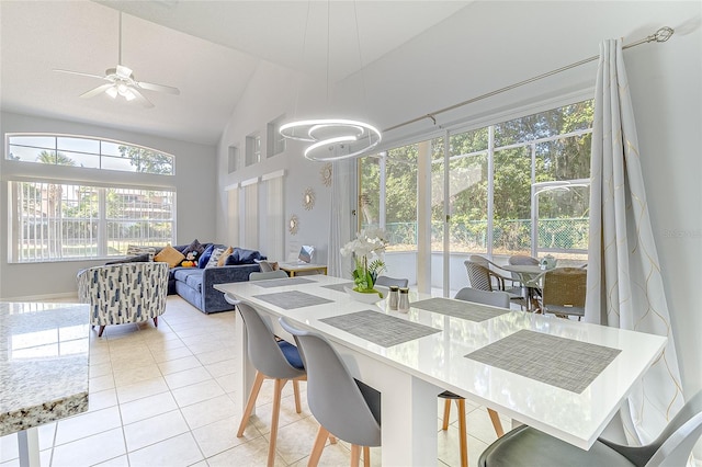 tiled dining room featuring ceiling fan and vaulted ceiling