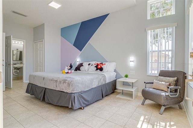 tiled bedroom featuring connected bathroom and a closet