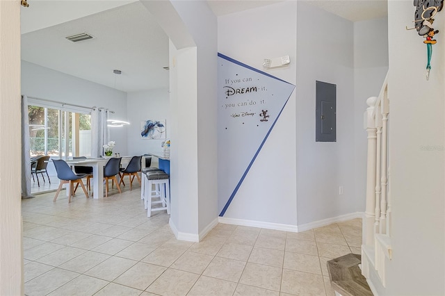 hall featuring light tile patterned floors and electric panel