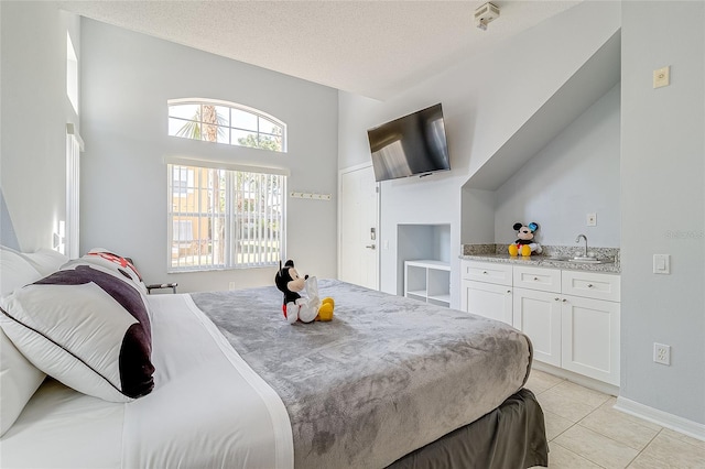 tiled bedroom featuring a towering ceiling and a textured ceiling