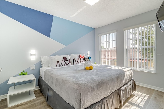 bedroom with light wood-type flooring and a textured ceiling