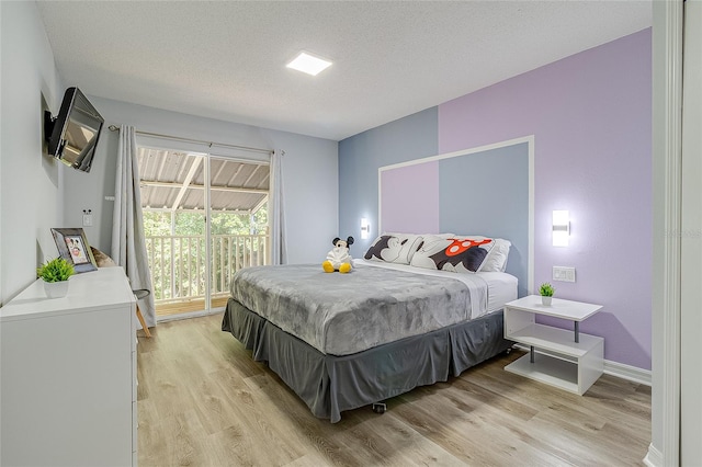 bedroom featuring a textured ceiling, light hardwood / wood-style flooring, and access to outside