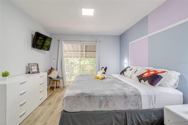 bedroom with access to outside and light hardwood / wood-style flooring