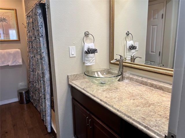 bathroom with curtained shower, hardwood / wood-style floors, and vanity