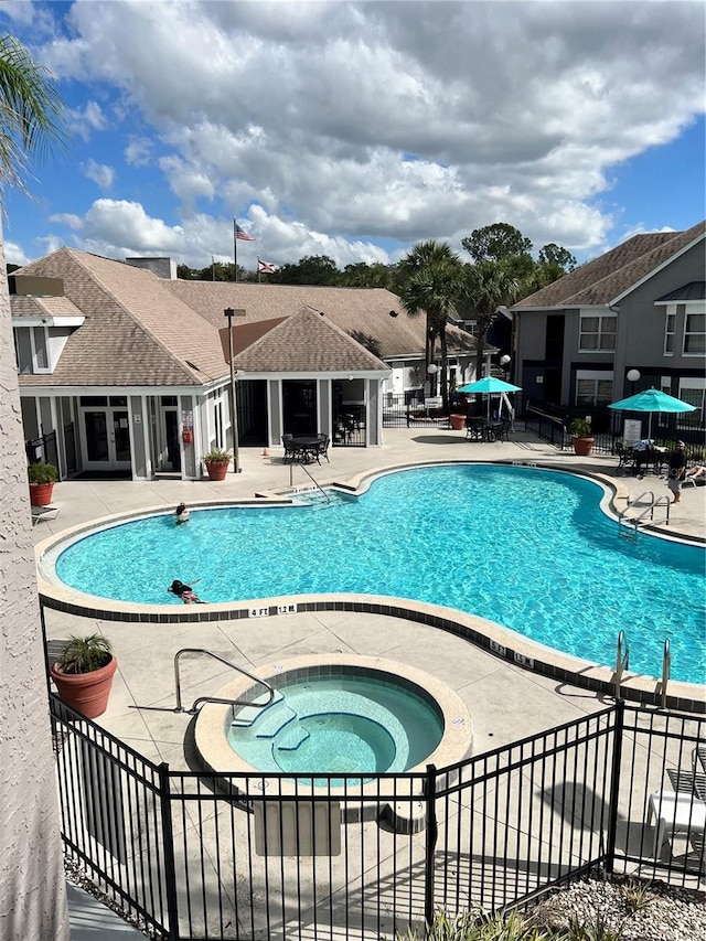 view of pool with a community hot tub and a patio