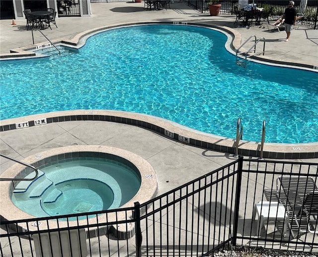 view of swimming pool with a community hot tub and a patio