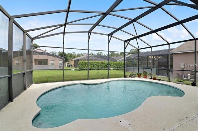 view of swimming pool with glass enclosure and a yard