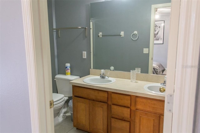 bathroom with tile patterned flooring, vanity, and toilet