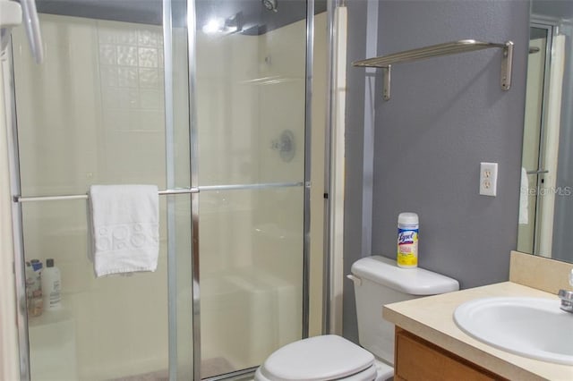 bathroom featuring vanity, toilet, and walk in shower