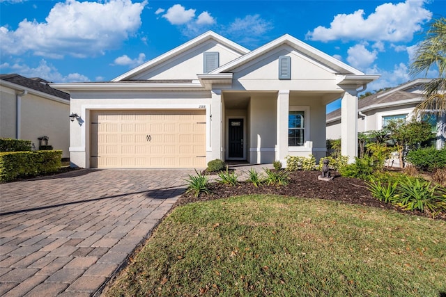 view of front facade featuring an attached garage, a front lawn, decorative driveway, and stucco siding