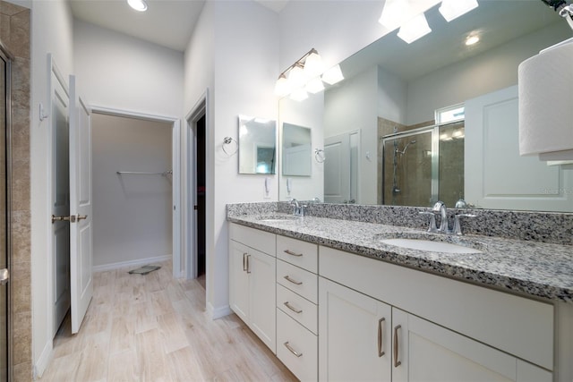 bathroom featuring a skylight, an enclosed shower, hardwood / wood-style flooring, and vanity