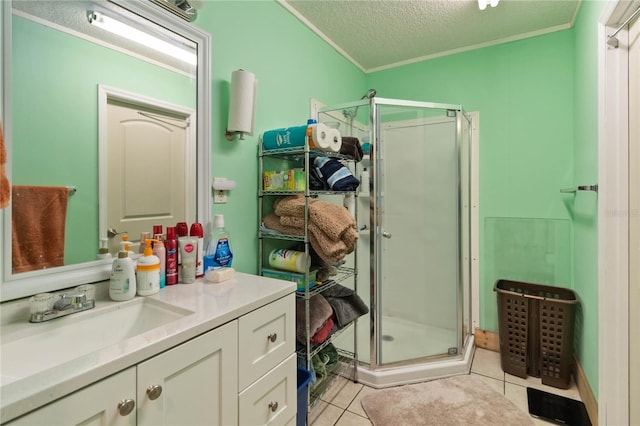 bathroom featuring tile patterned floors, a textured ceiling, a shower with door, vanity, and ornamental molding