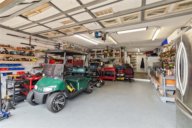 garage featuring stainless steel fridge, a workshop area, and a garage door opener