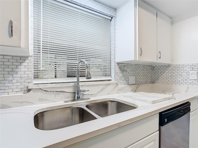 kitchen with dishwasher, light stone counters, sink, and white cabinets