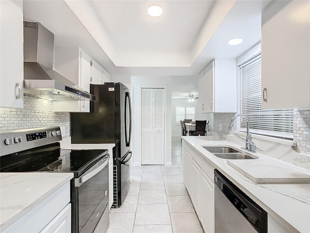 kitchen with stainless steel appliances, wall chimney exhaust hood, and white cabinetry