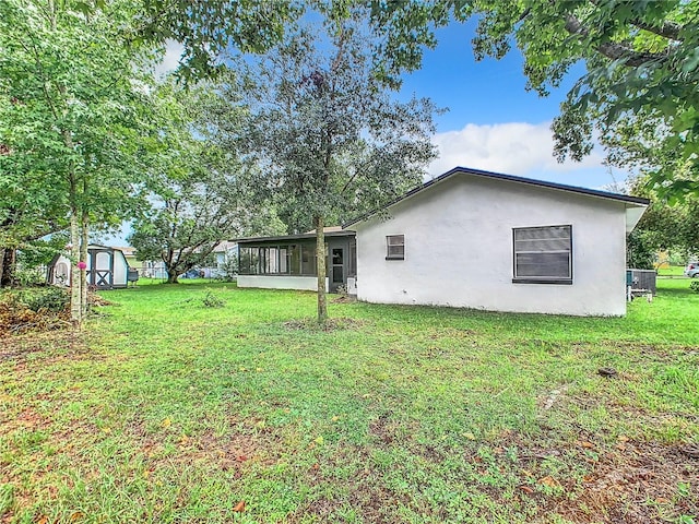 view of yard featuring a storage unit and a sunroom