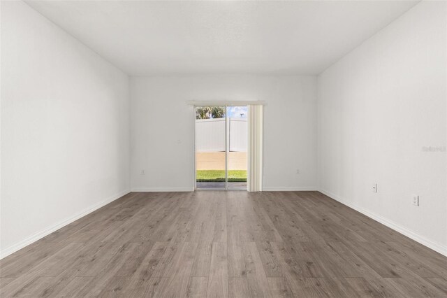 empty room with wood finished floors and baseboards