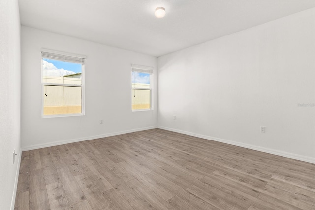 spare room with light wood finished floors and baseboards