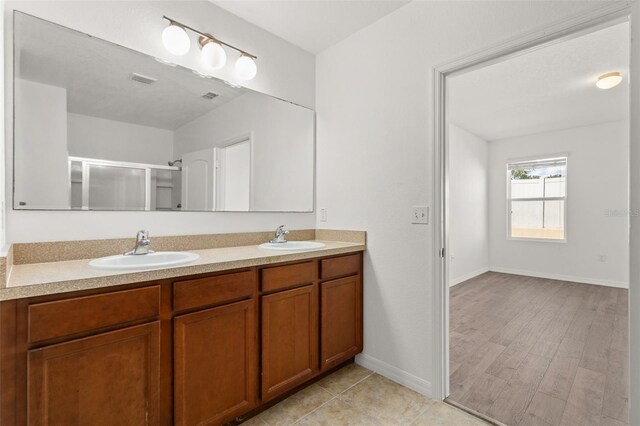 bathroom featuring wood-type flooring, an enclosed shower, and vanity