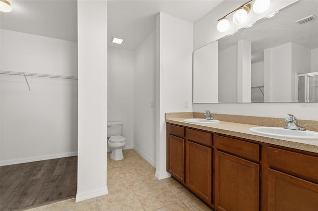 bathroom featuring vanity, toilet, hardwood / wood-style floors, and a shower with shower door